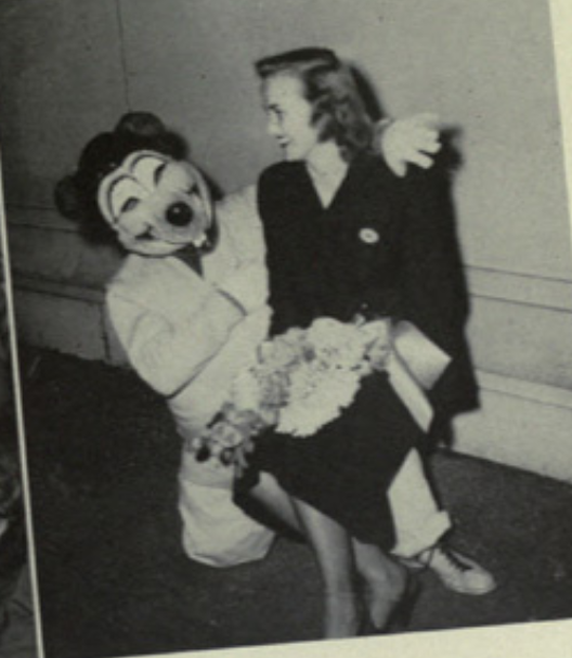 Archival scan: Oski kneeling beside a woman. Photo credit: Photographer/artist uncredited in supplied scan.