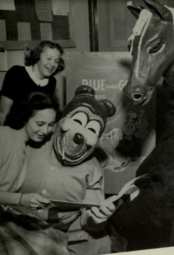 Archival scan: Oski sharing an open book with students. Photo credit: Photographer/artist uncredited in supplied scan.