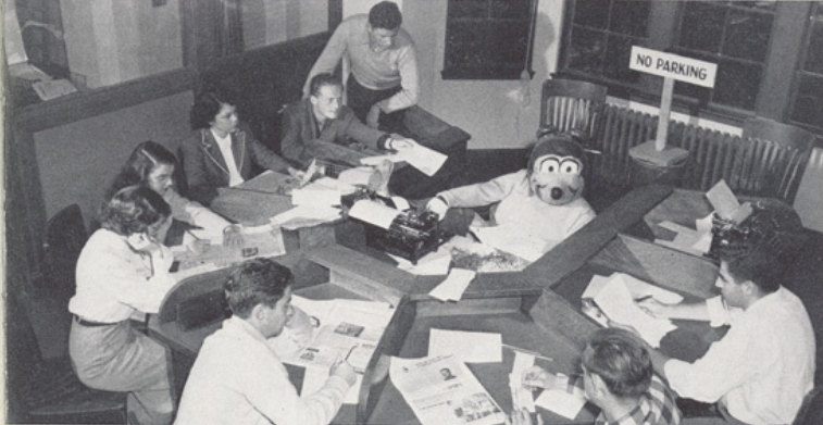 Archival scan: Oski peeking over a newsroom desk. Photo credit: Photographer/artist uncredited in supplied scan.