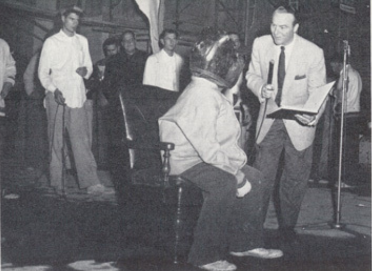 Archival scan: Oski performing with musicians at a rally. Photo credit: Photographer/artist uncredited in supplied scan.