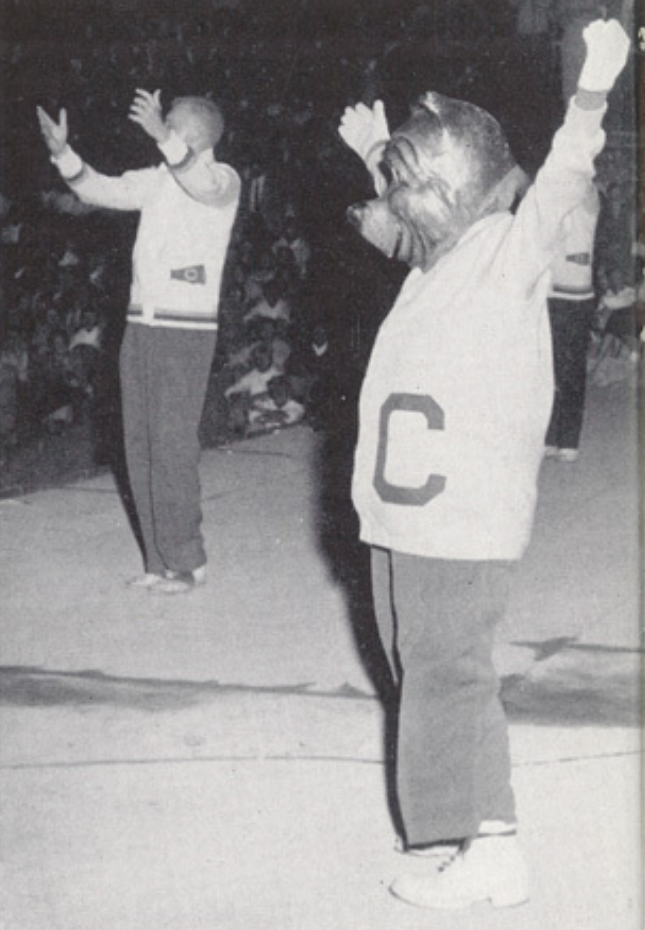 Archival scan: Oski raising both arms at a rally. Photo credit: Photographer/artist uncredited in supplied scan.