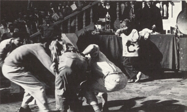 Archival scan: Oski bending forward during a sideline routine. Photo credit: Photographer/artist uncredited in supplied scan.