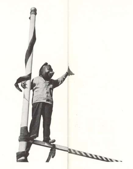 Archival scan: Oski reaching up between goalpost uprights. Photo credit: Photographer/artist uncredited in supplied scan.