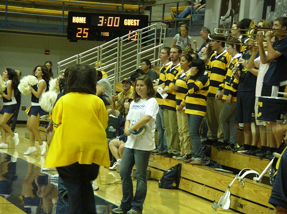 Oski stands in front of the Cal band and volleyball spectators. Photo credit: © BrokenSphere / Wikimedia Commons.